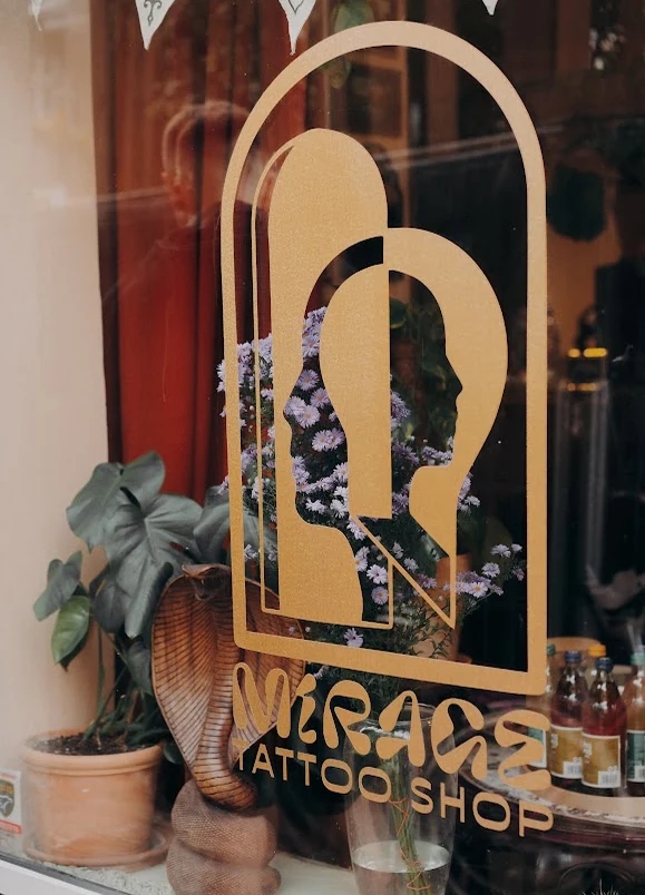 Logo Mirage na wejściu do studia, w otoczeniu roślin
